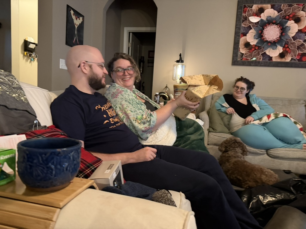 Family opening gifts together in the living room on Christmas Day